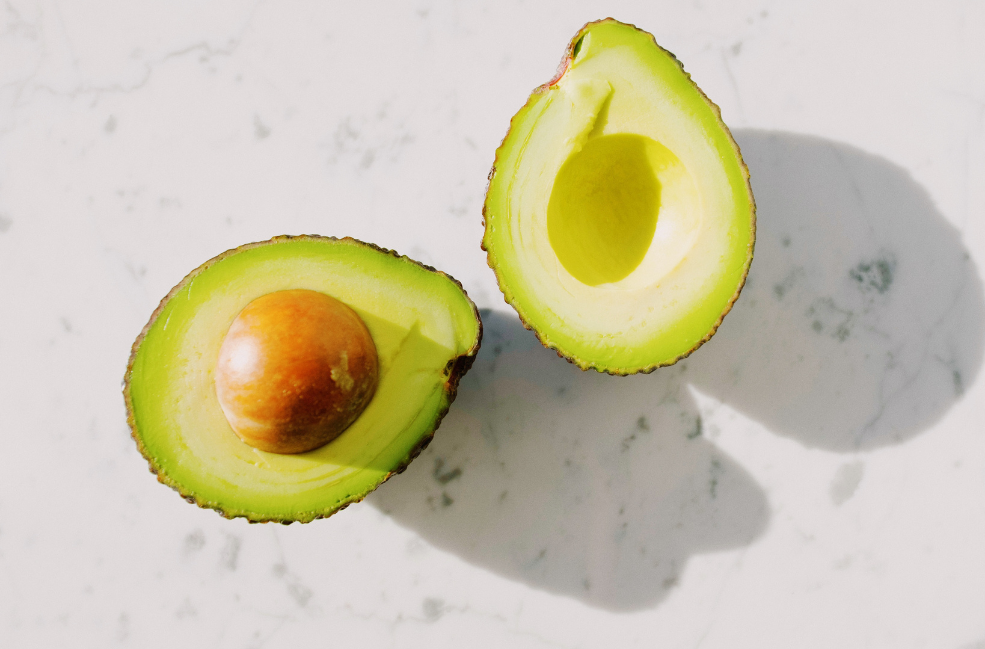 What are avocados good for? two avocado halves, one with the seed.